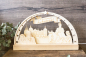 Preview: LED-Lichterbogen aus Holz mit graviertem Schloss Moritzburg, Aschenbrödel auf dem Schimmel neben dem Prinzen sowie Stiefmutter und Stiefschwester, Schriftband „Drei Haselnüsse für Aschenbrödel", umrahmt von Sternen, warmweißes Licht